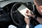 Man in Car With Notebook