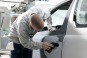 Auto-Body Shop Worker Sands a Car Door